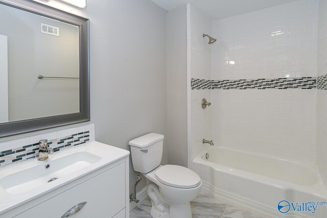 full bathroom featuring tile patterned flooring, decorative backsplash, toilet, vanity, and tiled shower / bath combo