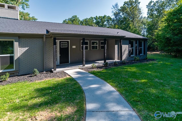 view of front of home featuring a porch, a front yard, and brick siding