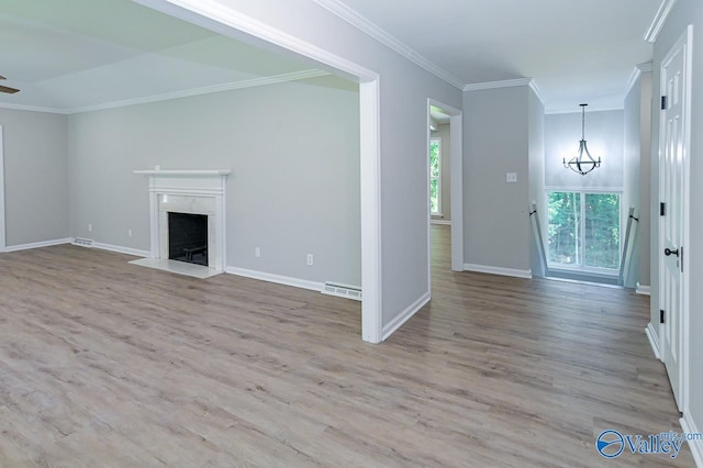 unfurnished living room featuring wood finished floors, a chandelier, ornamental molding, baseboards, and visible vents