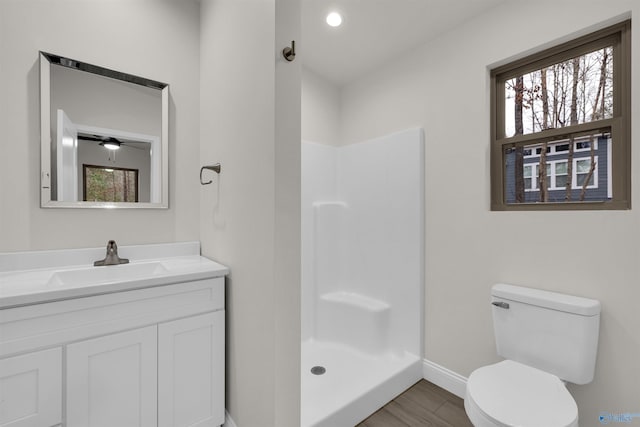 bathroom featuring vanity, toilet, wood-type flooring, and walk in shower