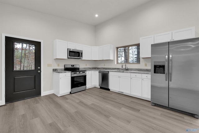 kitchen featuring light hardwood / wood-style flooring, white cabinets, stainless steel appliances, and sink