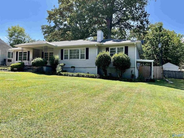 view of front of house with covered porch, a chimney, fence, and a front lawn