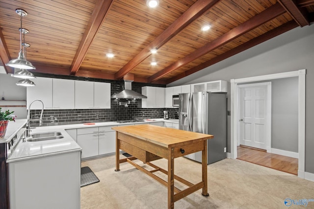 kitchen featuring white cabinets, decorative light fixtures, stainless steel appliances, and wall chimney exhaust hood