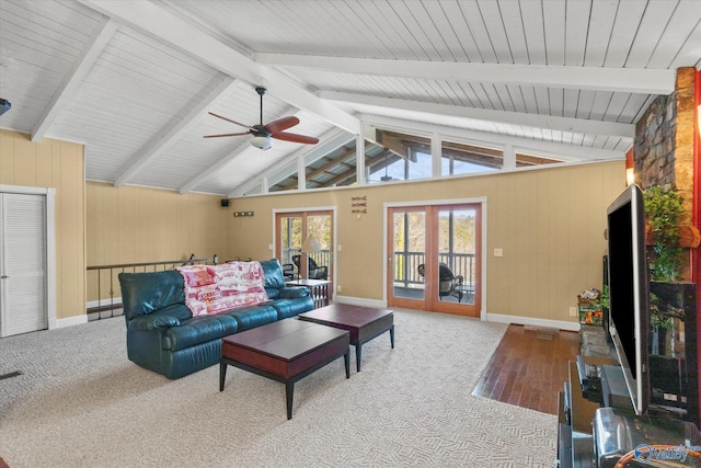 carpeted living room featuring ceiling fan, french doors, and lofted ceiling with beams