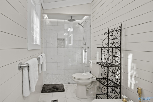 bathroom featuring tiled shower and wood walls