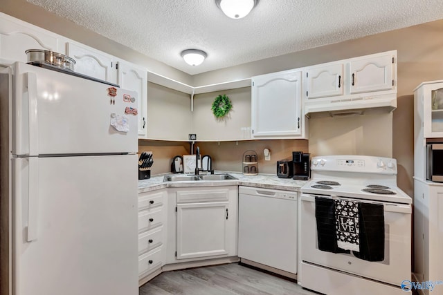 kitchen featuring white appliances, white cabinetry, a sink, and under cabinet range hood