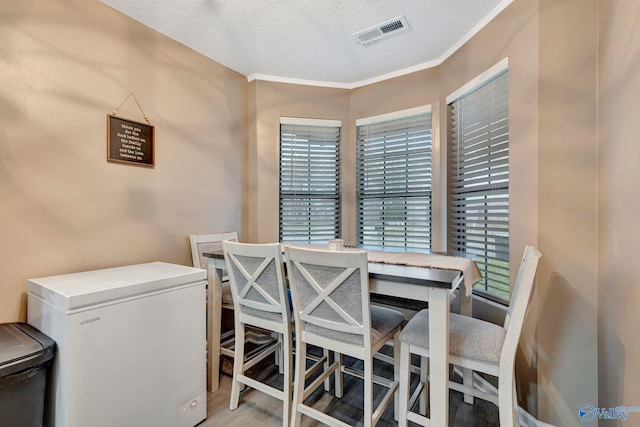 dining area featuring visible vents and a textured ceiling