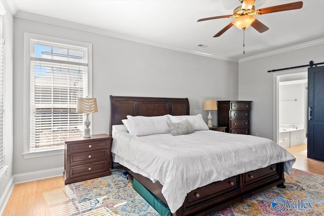 bedroom with a barn door, multiple windows, and crown molding