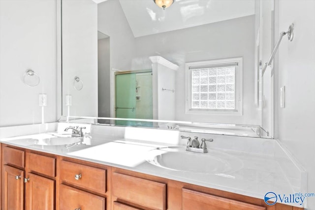 bathroom with a stall shower, a sink, and double vanity