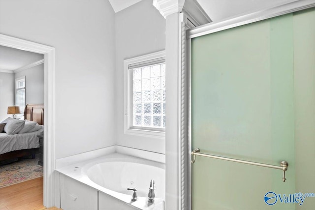 bathroom featuring ensuite bathroom, wood finished floors, a tub with jets, a stall shower, and crown molding