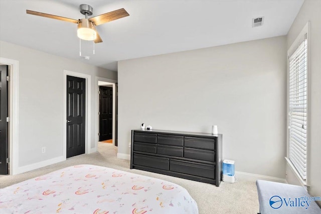 carpeted bedroom with baseboards, visible vents, and ceiling fan