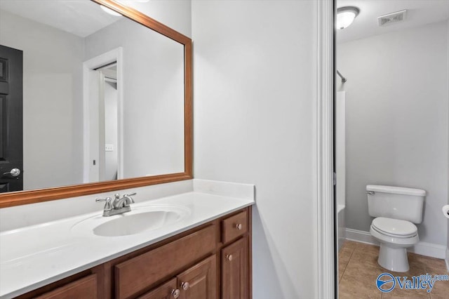 bathroom with tile patterned flooring, toilet, vanity, visible vents, and baseboards