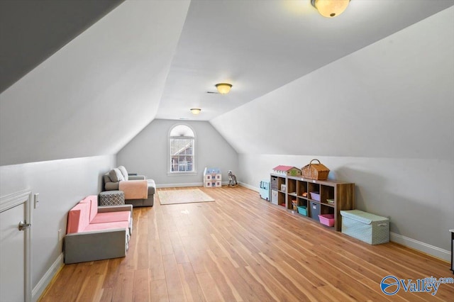 bonus room featuring baseboards, vaulted ceiling, and wood finished floors