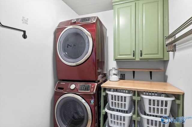 laundry room with cabinet space and stacked washer and clothes dryer