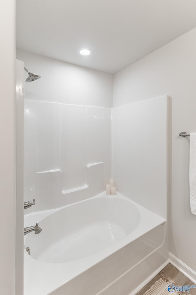 bathroom with wood-type flooring and  shower combination