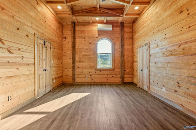 empty room with wood ceiling, hardwood / wood-style flooring, an AC wall unit, beamed ceiling, and wood walls