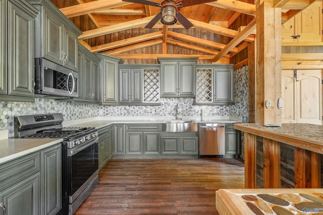 kitchen with sink, lofted ceiling with beams, dark hardwood / wood-style floors, backsplash, and appliances with stainless steel finishes