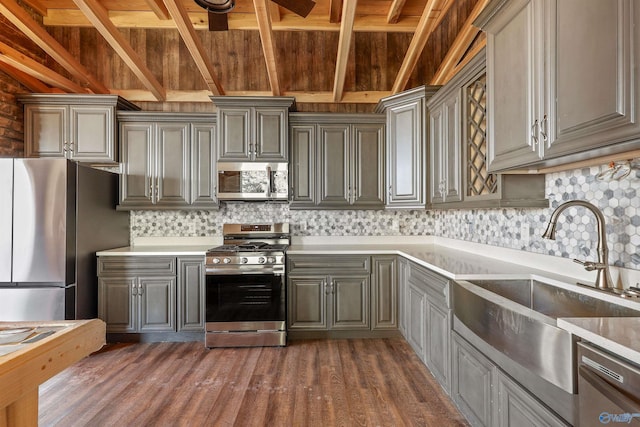 kitchen featuring sink, gray cabinets, appliances with stainless steel finishes, tasteful backsplash, and dark hardwood / wood-style flooring