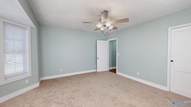 unfurnished bedroom featuring baseboards, carpet floors, a textured ceiling, and ceiling fan