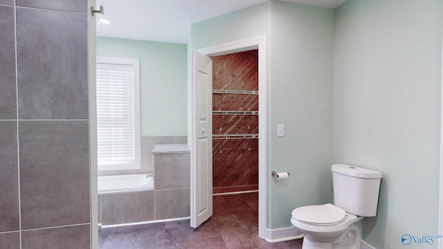 bathroom featuring a garden tub and toilet