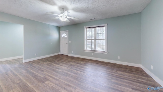 unfurnished room with visible vents, baseboards, and wood finished floors