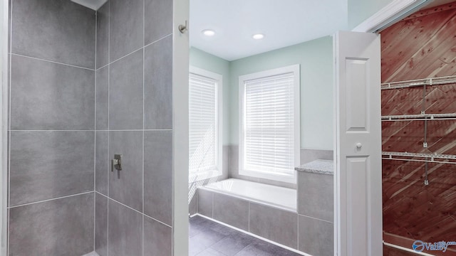 full bathroom with a bath, tile patterned flooring, and a tile shower