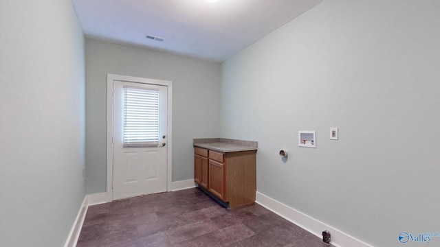 laundry area featuring hookup for a washing machine, cabinet space, visible vents, and baseboards