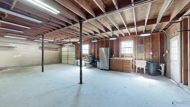 basement with freestanding refrigerator and a garage