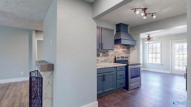 kitchen featuring decorative backsplash, stainless steel electric stove, baseboards, and premium range hood