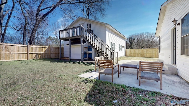 back of house with a lawn, a fenced backyard, a wooden deck, stairs, and a patio area