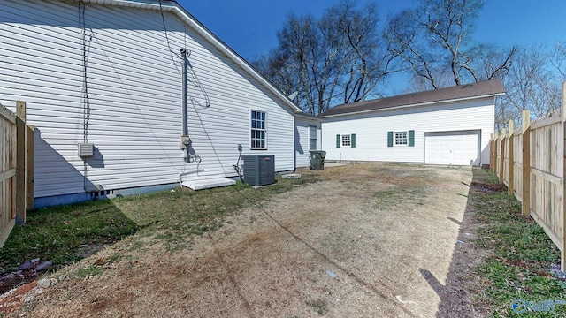 view of home's exterior with an outbuilding, driveway, fence, cooling unit, and a garage