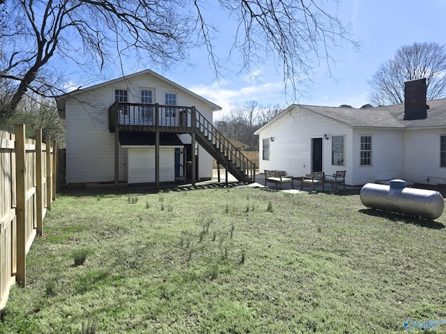 back of property with a deck, a patio, fence, a yard, and stairs