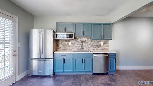 kitchen with a sink, tasteful backsplash, stainless steel appliances, light countertops, and baseboards