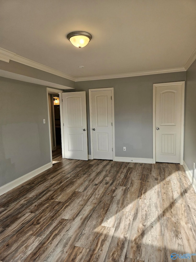 unfurnished bedroom with crown molding, wood-type flooring, and a closet