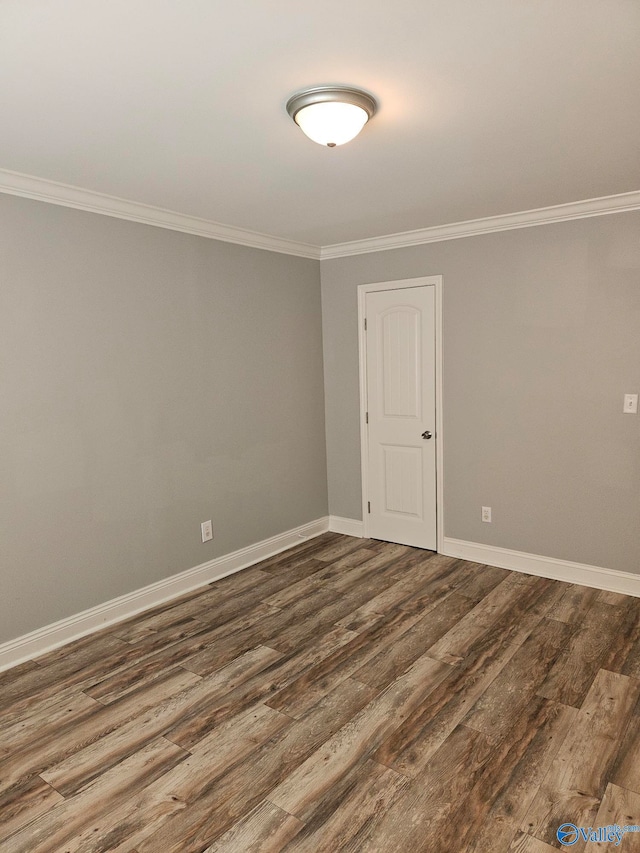 unfurnished room featuring ornamental molding and dark hardwood / wood-style floors