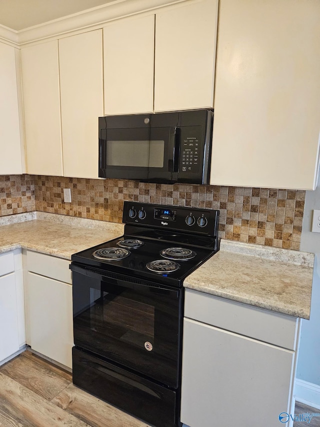 kitchen with backsplash, black appliances, light hardwood / wood-style floors, and white cabinets