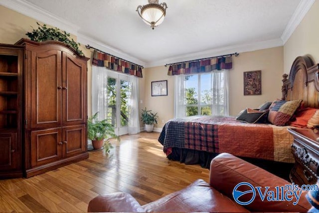 bedroom featuring light wood finished floors, access to outside, multiple windows, and crown molding