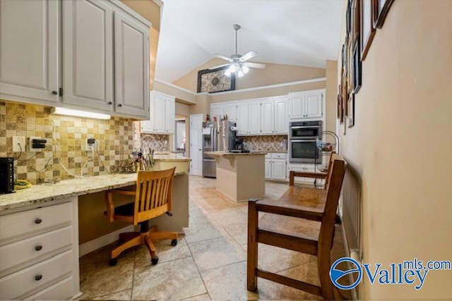 kitchen with tasteful backsplash, a ceiling fan, built in study area, stainless steel appliances, and white cabinetry