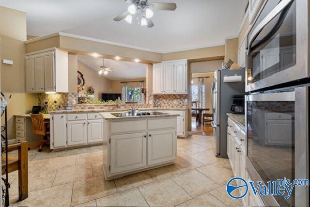 kitchen with light countertops, appliances with stainless steel finishes, a ceiling fan, and decorative backsplash