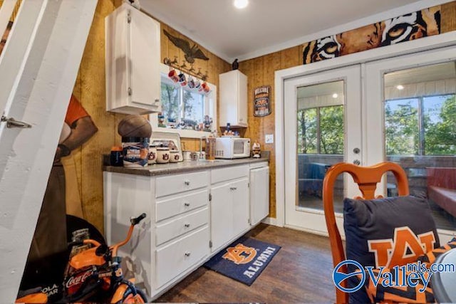 kitchen featuring white microwave, white cabinetry, dark wood-style flooring, and french doors