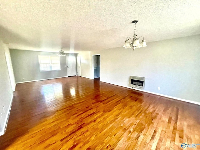 interior space with a textured ceiling, ceiling fan with notable chandelier, wood-type flooring, and heating unit