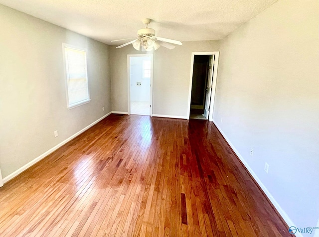 unfurnished room with ceiling fan, a textured ceiling, and light wood-type flooring