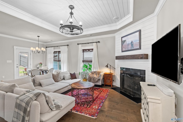 living area with a fireplace with flush hearth, a notable chandelier, a tray ceiling, crown molding, and dark wood-style flooring