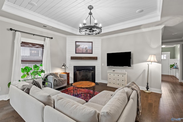 living area with visible vents, dark wood finished floors, a fireplace, crown molding, and a chandelier