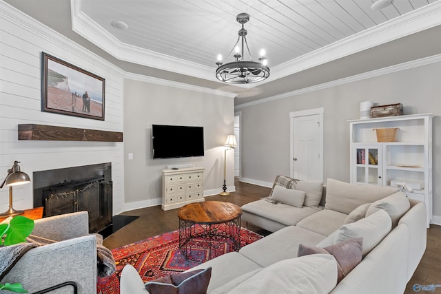 living room featuring baseboards, a chandelier, a tray ceiling, ornamental molding, and dark wood-style flooring