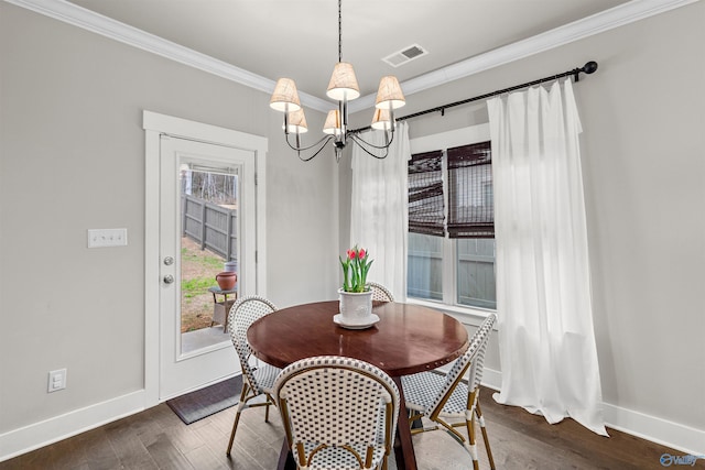 dining space featuring visible vents, crown molding, baseboards, dark wood-type flooring, and a notable chandelier