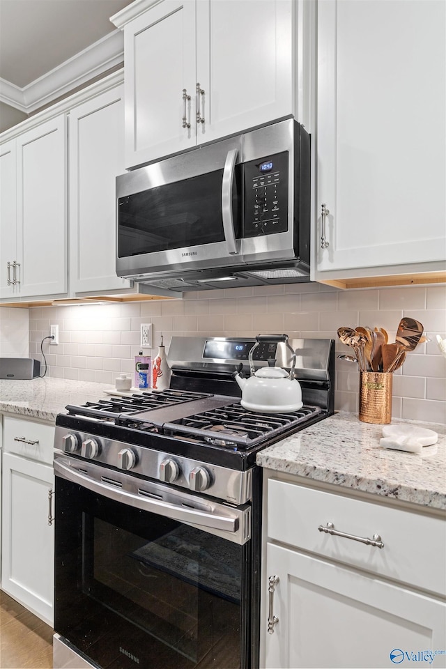 kitchen featuring white cabinetry, tasteful backsplash, and stainless steel appliances