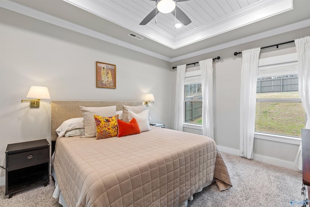 carpeted bedroom with a ceiling fan, visible vents, baseboards, crown molding, and a raised ceiling