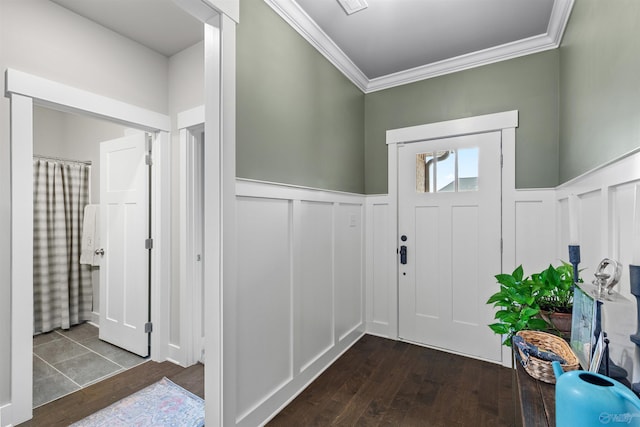 entrance foyer with a wainscoted wall, crown molding, a decorative wall, and dark wood-style flooring