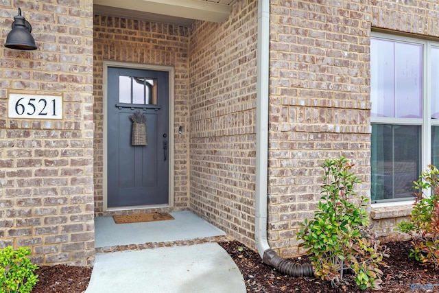 entrance to property featuring brick siding